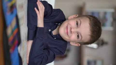 Portrait of preschooler looking at camera while sitting at table Video stock 170796145