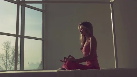 Portrait of pretty fair-skinned blond woman sitting in lotus position and Stock-Footage 72411157