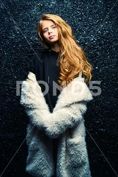 A portrait of a pretty fashionable girl posing over the black background. Fas Stock Photos