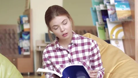 Portrait of pretty female student learning something new from the book Stock-Footage 73317495