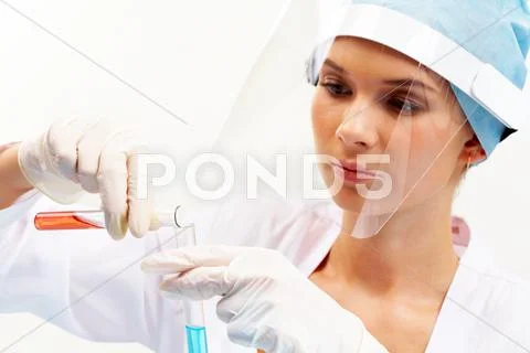 Portrait of pretty nurse pouring liquid into medical tube Stock Photos
