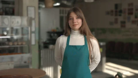 Portrait of pretty waitress on apron posing at local cafe Stock Footage 163978010