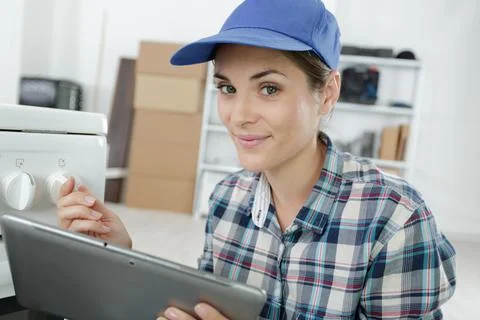 Portrait of pretty young technician using tablet Stock Photos