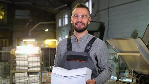 Portrait of print worker with paper for printing Stock Footage 257044131