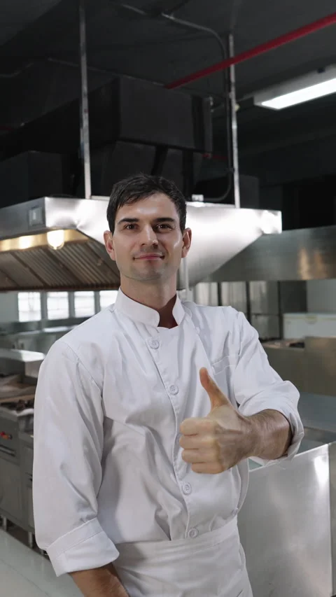 Portrait of professional chef posing proudly with thumbs up gesture in hotel Stock Footage 321929701