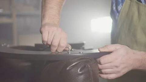 Portrait professional man in an apron with a beard in the workshop is engaged in Stock Footage 98791607