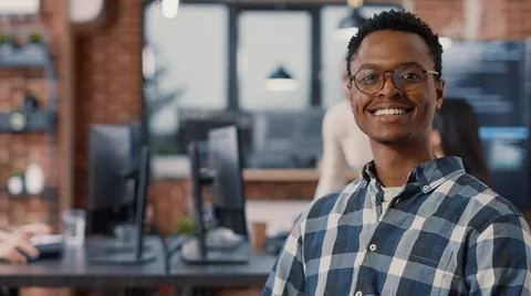 Portrait of programer sitting down looking at laptop screen and looking up 写真素材