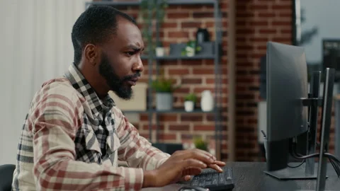 Portrait of programer typing programming code on computer keyboard turning head Stock Footage 168245846