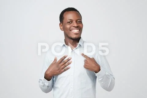Portrait of proud handsome african man standing, looking at camera and pointing Stock Photos