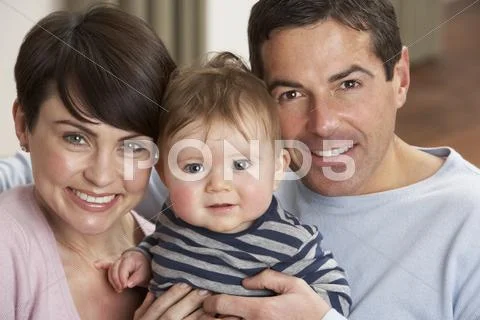 Portrait Of Proud Parents With Baby Son At Home Stock Photos