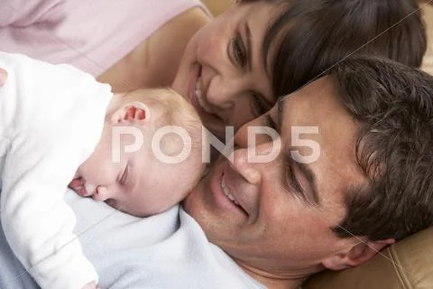 Portrait Of Proud Parents With Newborn Baby At Home Stock Photos