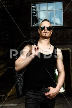 Portrait of a punk man in the street. Guy in the backyard. Fashion, subcultur Stock Photos