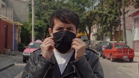 Portrait of a punk rocker putting on a face mask and wearing leather jacket Stock Footage