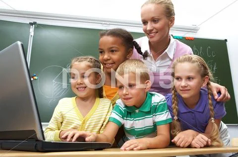 Portrait of pupils looking at the laptop with teacher near by Stock Photos