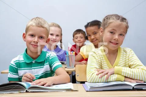 Portrait of pupils looking at page of encyclopaedia at reading lesson Stock Photos