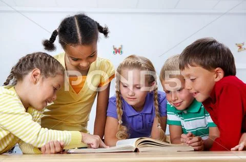 Portrait of pupils looking at page of encyclopaedia at reading lesson Stock Photos