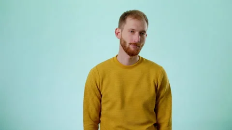 Portrait Of Puzzled And Embarrassed Handsome Bearded Man In Yellow Shirt Stock Footage 170192411