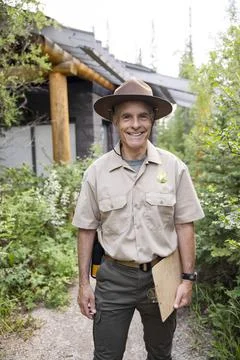 Portrait of ranger on forest path next to hut Stock Photos