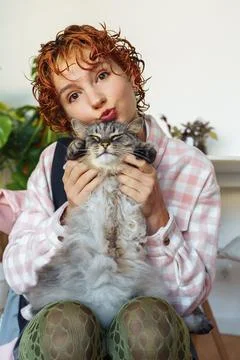 Portrait of red-haired attractive young woman with grey big cat Fotos Stock