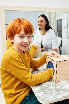 Portrait of a red-haired boy during classes with a child development specia.. Stock Photos
