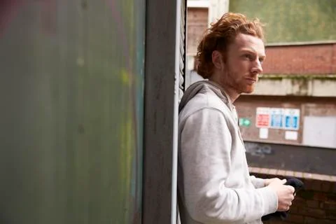 Portrait of red haired man looking away in an urban setting Stock Photos