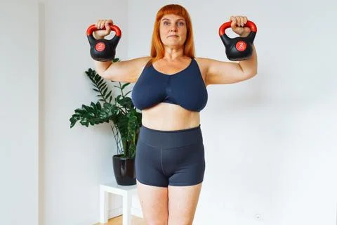 Portrait red-haired middle-aged woman, plump, with large bust size, doing Stock Photos