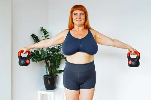 Portrait red-haired middle-aged woman, plump, with large bust size, doing Stock Photos