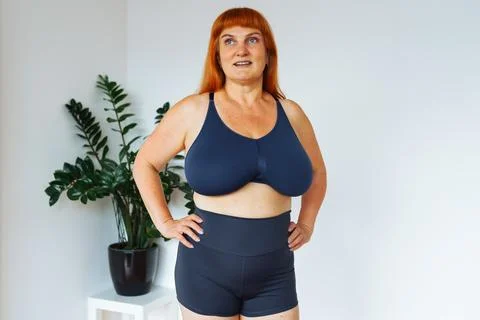 Portrait red-haired middle-aged woman, plump, with large bust size, doing Stock Photos