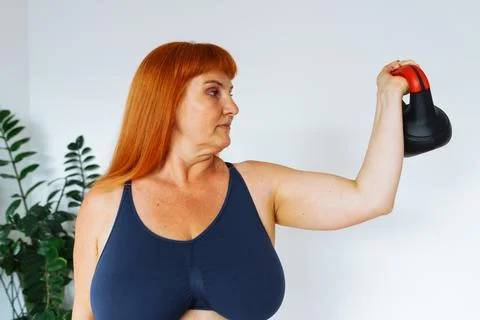 Portrait red-haired middle-aged woman, plump, with large bust size, doing Stock Photos