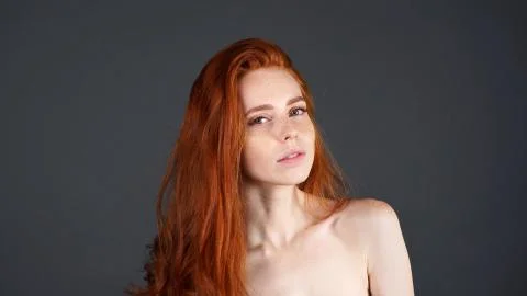Portrait of redhead model on a gray background. Perfect girl is posing in Studio Stock Photos