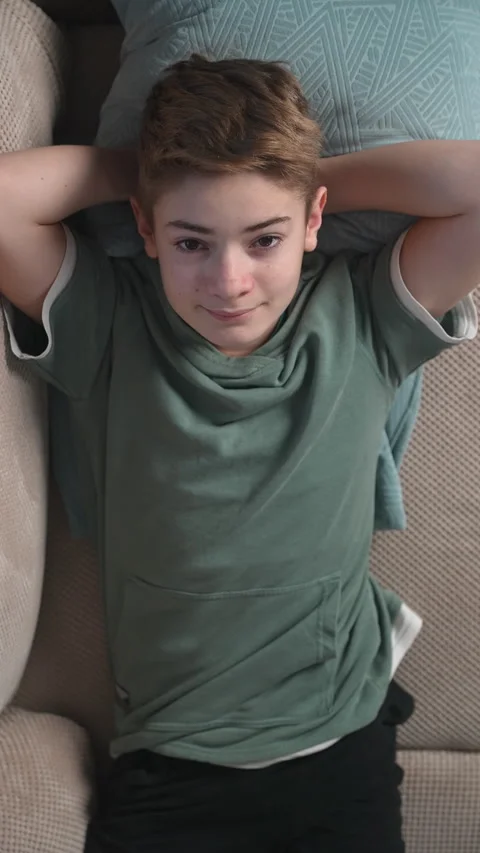 Portrait of relaxed boy lying on sofa, looking to camera, smiling,  Stock Footage 270368258