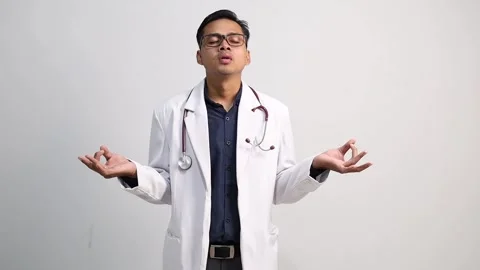 Portrait of relieved determined Asian doctor male meditates with closed eyes Stock Footage 316728053