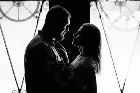 Portrait of a romantic couple in a backlight from a window or door, silhouett Stock Photos