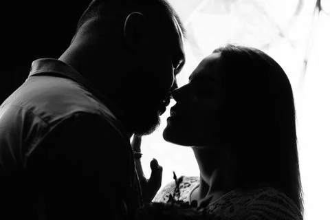 Portrait of a romantic couple in a backlight from a window or door, silhouett Stock Photos