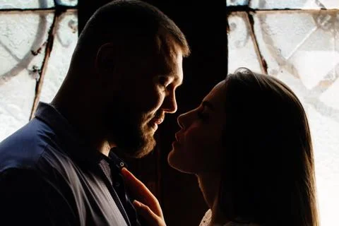 Portrait of a romantic couple in a backlight from a window or door, silhouett Stock Photos