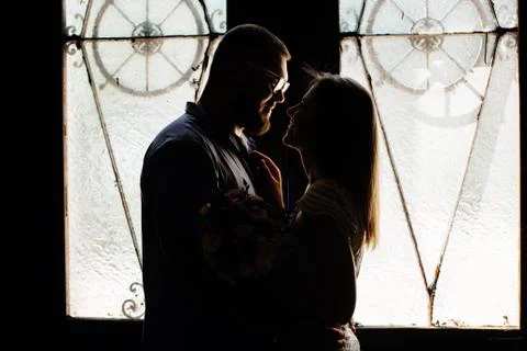 Portrait of a romantic couple in a backlight from a window or door, silhouett Stock Photos