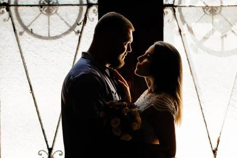 Portrait of a romantic couple in a backlight from a window or door, silhouett Stock Photos
