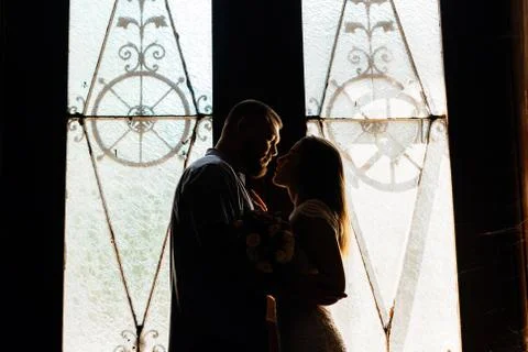 Portrait of a romantic couple in a backlight from a window or door, silhouett Stock Photos