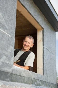 Portrait of a roofer looking by a dormer window Fotos Stock