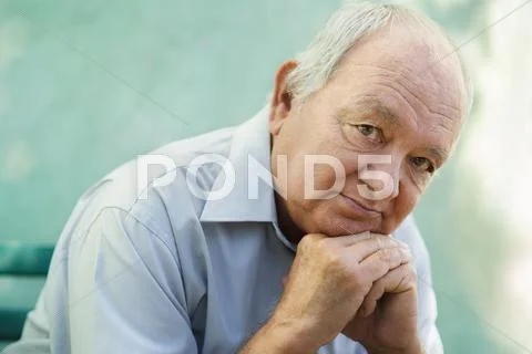 Portrait of sad bald senior man looking at camera Stock Photos
