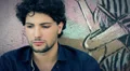 portrait Sad, depressed young man sitting near a graffiti wall HD Footage