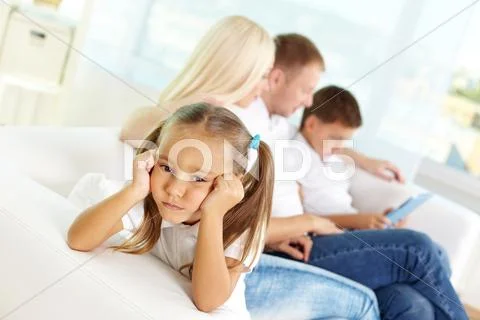Portrait of sad girl on background of her parents and brother Stock Photos