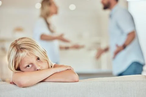 Portrait of sad little girl, parents fighting in the background. Depressed child Stock Photos