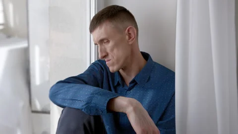 Portrait of a sad man sitting by the window. Problems and stress. Stock Footage 272918778