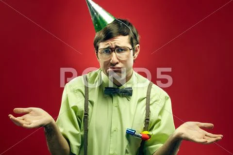 Portrait of sad nerd in party hat at a loss Stock Photos