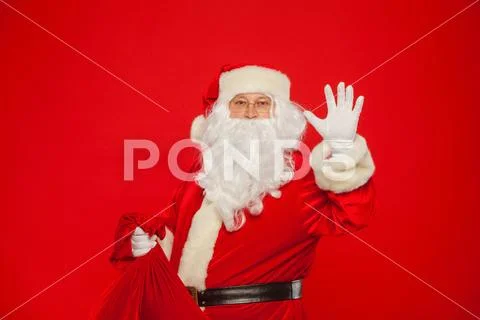 Portrait of Santa Claus with huge red sack hand up looking at ca Stock Photos