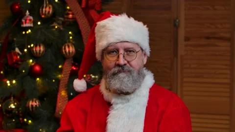 Portrait of Santa Claus looking into the camera showing thumbs up gesture. Old Stock Footage 145386712
