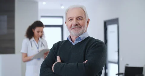 Portrait satisfied elderly man, happy patient crossing arms smiles in hospital Video stock 150239048