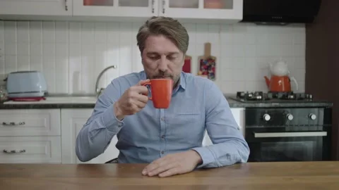 Portrait of a satisfied man drinking tea, coffee in the kitchen. Stock Footage 188927822