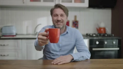 Portrait of a satisfied man drinking tea, coffee in the kitchen. Stock Footage 188928812